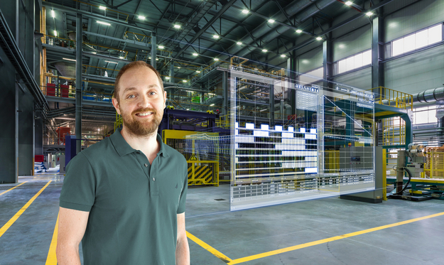 A man stands in a factory hall, digital data appears next to him.