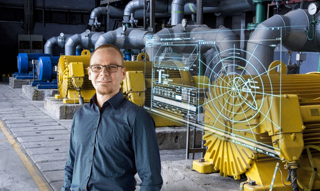 A man stands next to digital data appears in front of and above large drive motors.