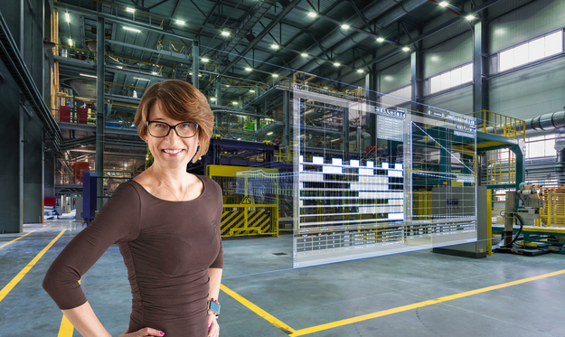A woman stands in a factory hall, digital data appears next to her.