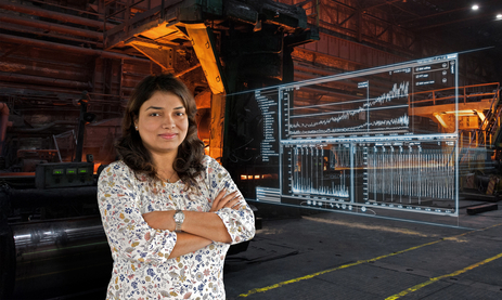 Woman standing in front of steel processing in hall.