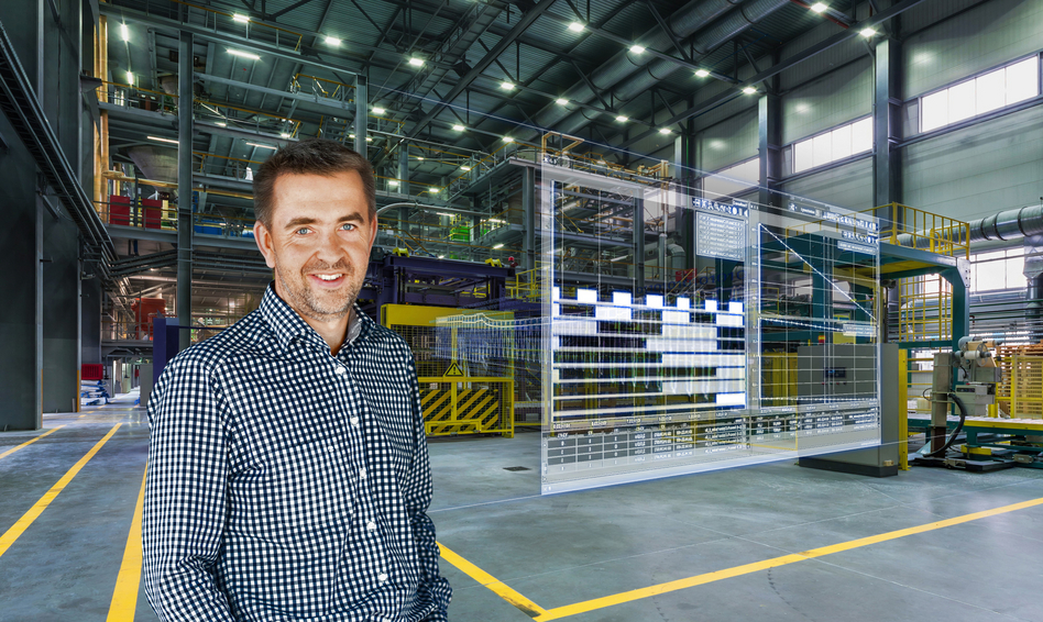 Ein Mann steht in einer Fabrikhalle, neben ihm erscheinen digitale Daten.