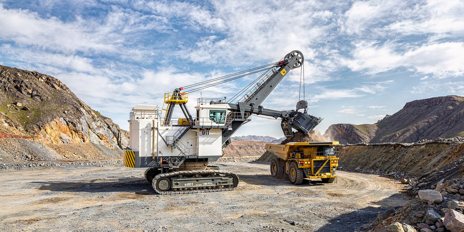 Excavator loading a large mining truck in an open-pit mine.